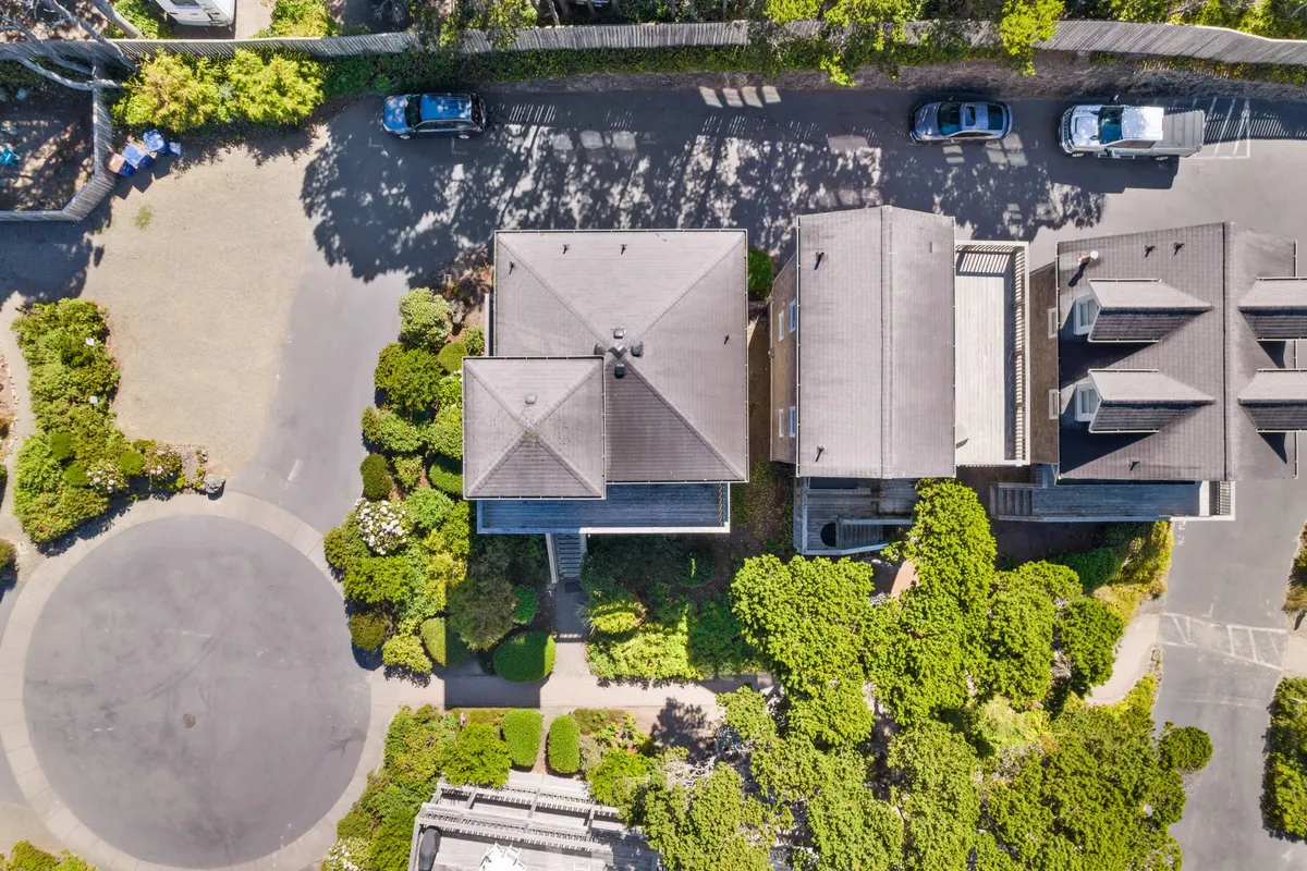 An elegant exterior shot showing Luna Bella’s well-manicured gardens, circular driveway, and multiple rooftops, framed by lush greenery. The mood is peaceful and welcoming, suggesting a restful home base after a day’s adventures.